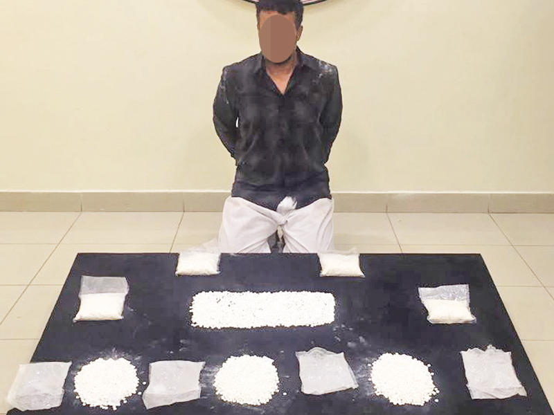 المتهم وأمامه المضبوطات