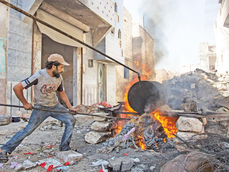 سوري يستخدم البلاستيك لإنتاج الوقود في حلب أمس الأول (إي بي إيه)