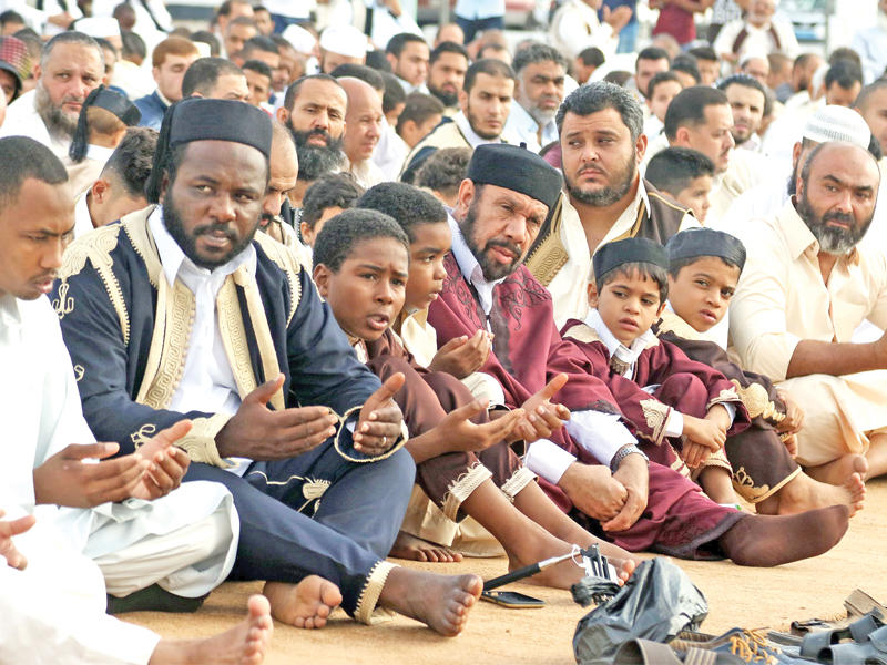 ليبيون ارتدى بعضهم الزي الوطني خلال أداء صلاة العيد في طرابلس الغرب أمس (أ ف ب)