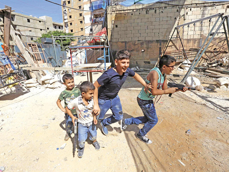 فتية فلسطينيون وسوريون يلهون في مخيم شاتيلا للاجئين جنوب بيروت أمس (أ ف ب)