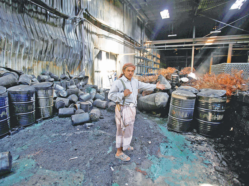 مسلح داخل مصنع أنابيب قصفته مقاتلات التحالف في صنعاء أمس (رويترز)