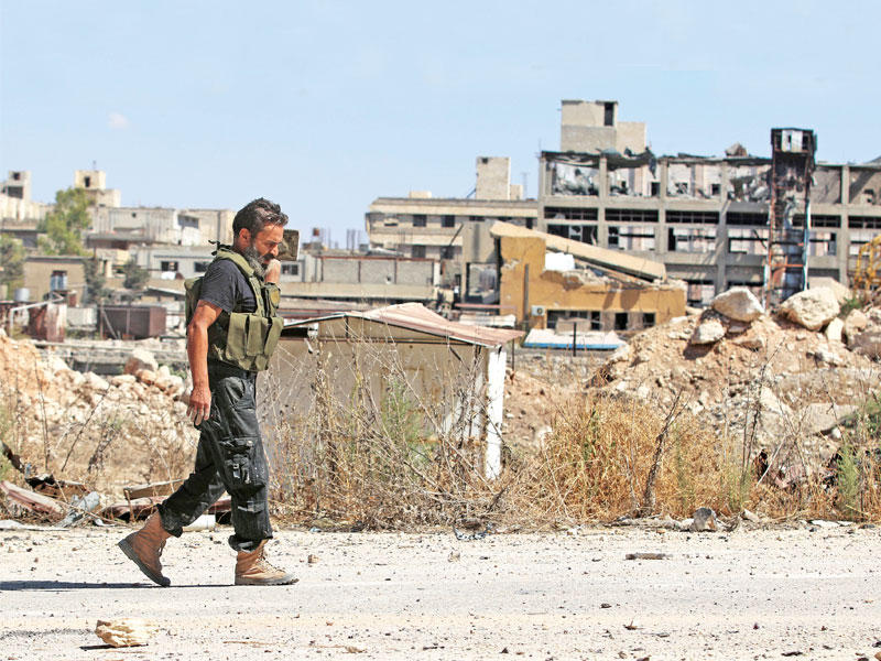 مقاتل معارض يمر قرب طريق الكاستيلو في حلب أمس الأول  (رويترز)