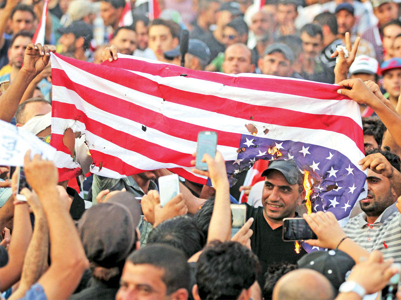 أنصار مقتدى الصدر يحرقون العلم الأميركي خلال تظاهرة لهم لمحاربة الفساد في ساحة التحرير وسط بغداد أمس الأول (أ ف ب)