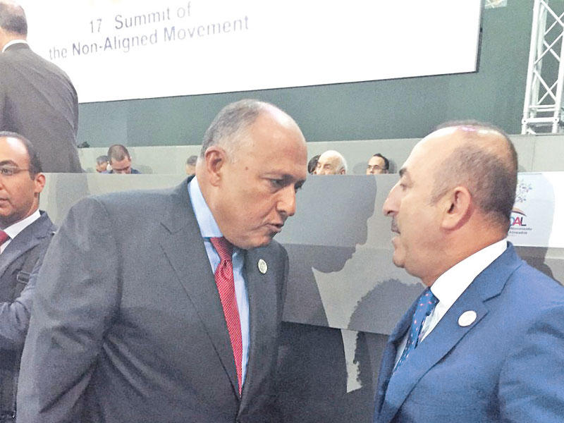 شكري ونظيره التركي خلال لقائهما على هامش قمة عدم الانحياز في فنزويلا أمس الأول