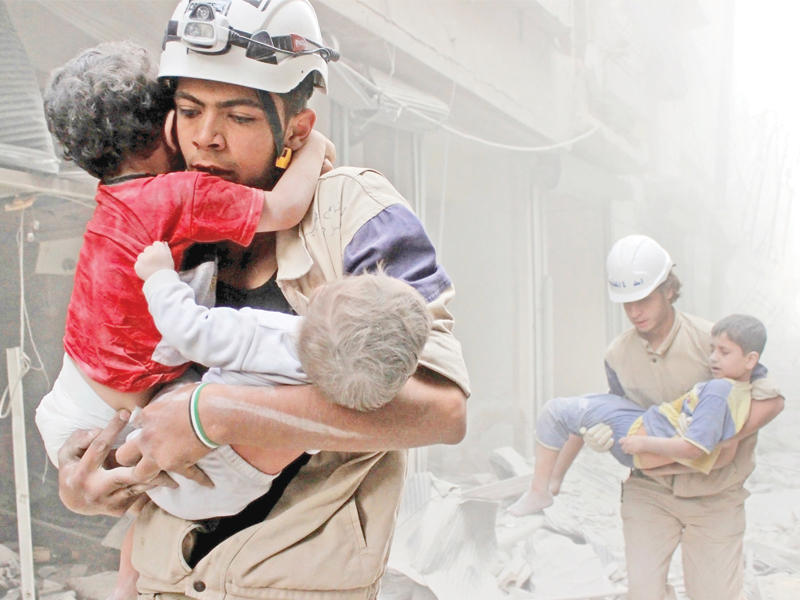 متطوعان من «الخوذ البيضاء» ينقذان اطفالا في حلبn