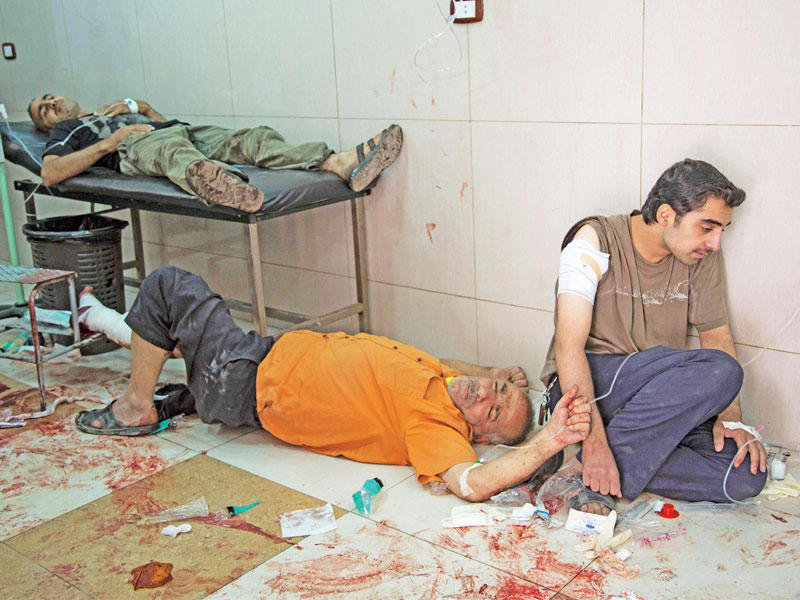 سوريون داخل مستشفى ميداني في شرق حلب أمس (أ ف ب)