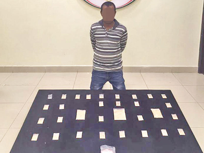 المتهم وأمامه المضبوطات