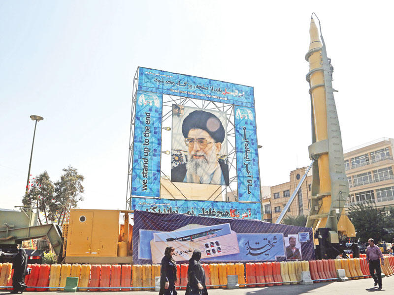 ايرانيون يمرون بجوار صاروخ متوسط المدى وسط طهران أمس        (إي بي أيه)