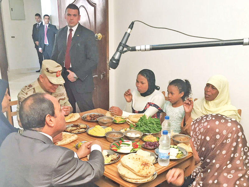 السيسي وصبحي يتناولان وجبة طعام مع إحدى الأسر المستفيدة من مشروع تطوير عشوائيات غيط العنب بالإسكندرية أمس 