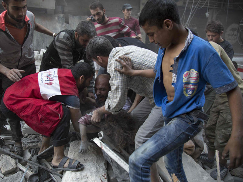 مسعفون ينتشلون ضحايا غارة على أحد أحياء مدينة حلب السورية 