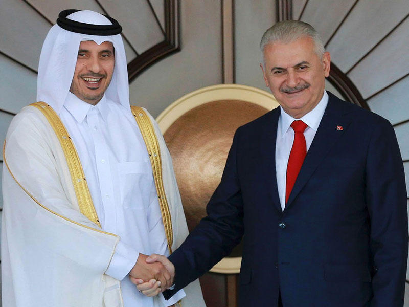 رئيس الوزراء التركي مصافحاً نظيره القطري