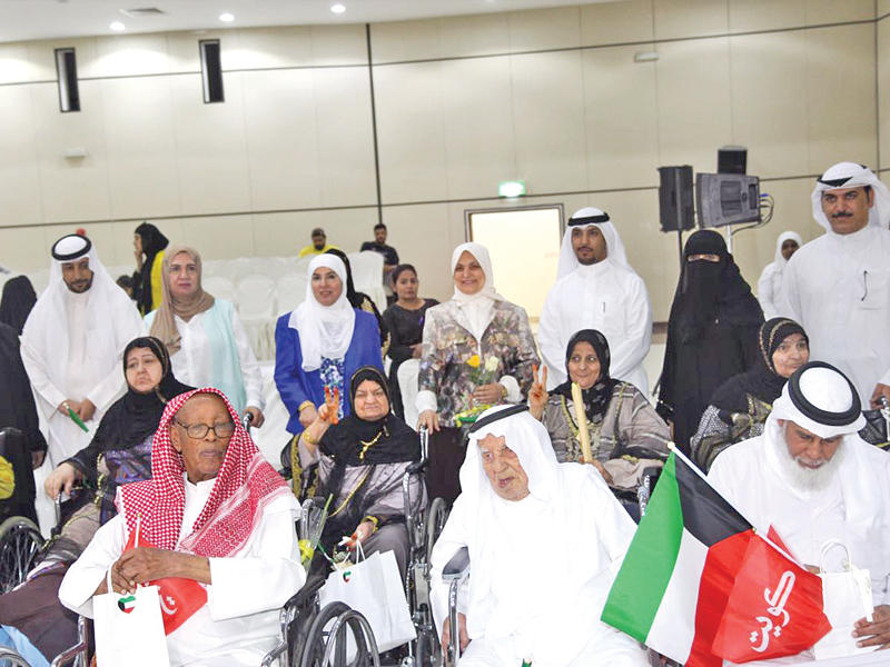 الصبيح والملا تتوسطان مجموعة من كبار السن خلال الاحتفال بيومهم العالمي