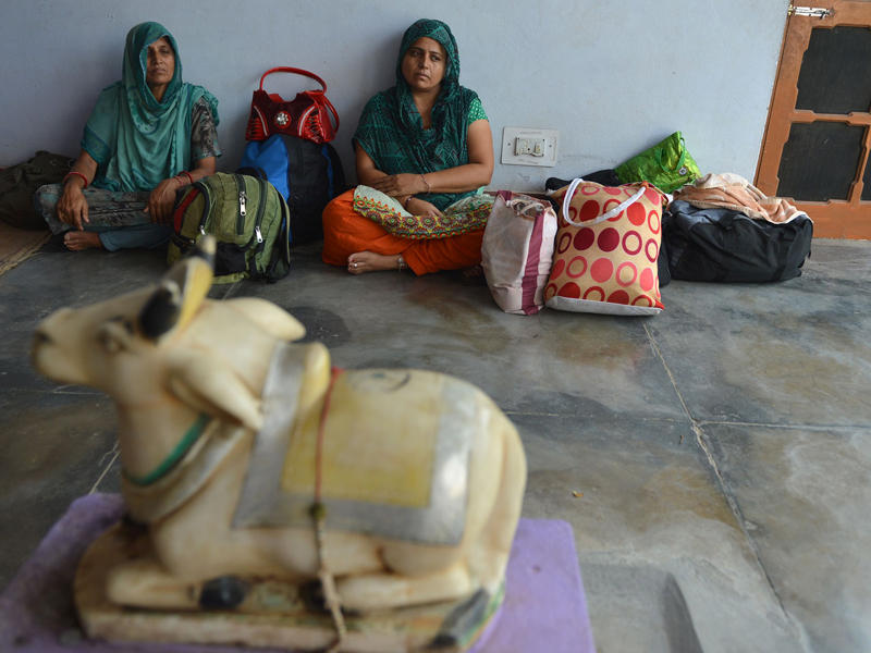 هنديتان داخل معبد هندوسي بقطاع اخنور غرب جامو وكشمير بعد إخلاء قريتهما الحدودية أمس (أ ف ب)