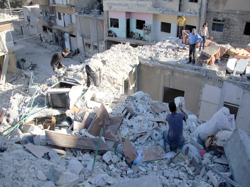 السوري يحيى معتوق (أسفل)، يبحث عما تبقى من منزله في أدلب الذي تعرض لغارة قبل أيام. وانتشر فيديو لأحد عاملي الإنقاذ منهاراً من البكاء بعد العثور على الطفلة وحيدة ابنة يحيى حية ترزق تحت الركام (أ ف ب)