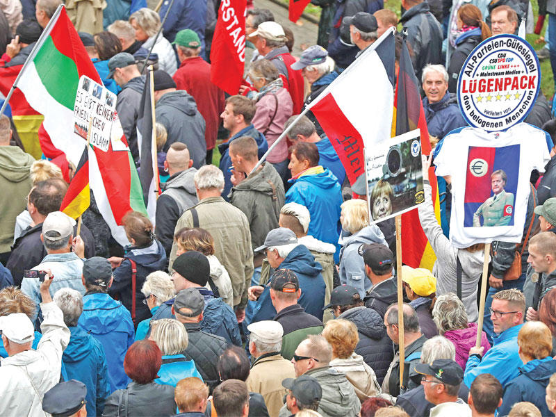 أنصار بيغيدا أثناء تظاهرهم ضد ميركل في دريدسن أمس ( أ ف ب)