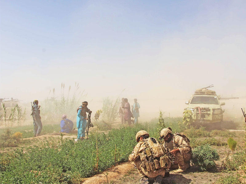 جنود أفغان وعناصر ميليشيات مناصرة للجيش في هلمند أمس (أ ف ب)