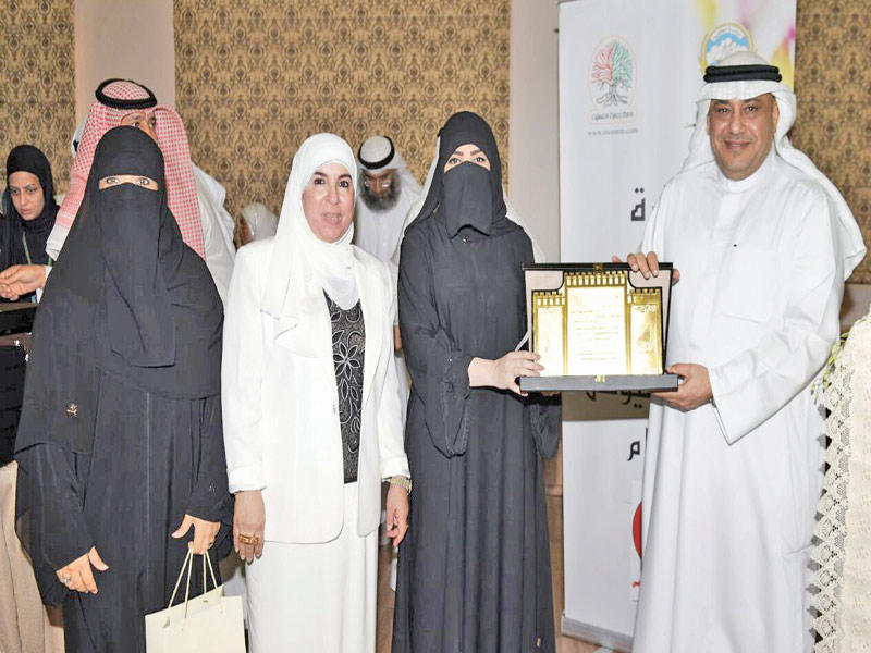 المطيري والملا يكرمان إحدى المشاركات في الاحتفال 