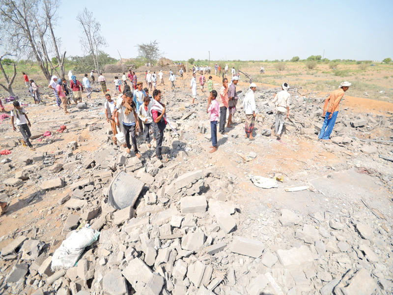 يمنيون في موقع استهدفته مقاتلات التحالف بالحديدة الساحلية أمس  (رويترز) 