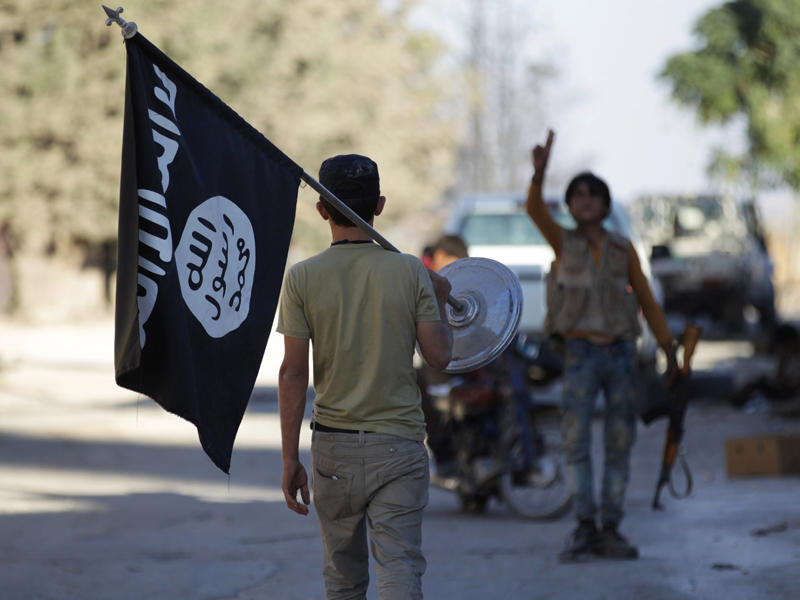 مقاتل في الجيش الحر يزيل علم داعش بعد السيطرة على قرية آخترين شمالي حلب