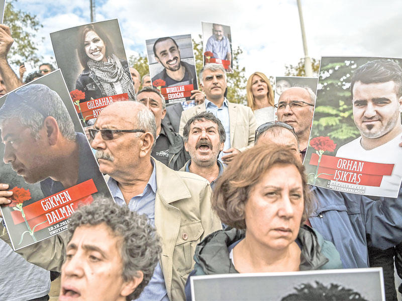 أتراك يحملون أمس في اسطنبول صور ضحايا التفجير الانتحاري الذي استهدف مسيرة كردية في أنقرة قبل عام بالتمامttttt      (أ ف ب)