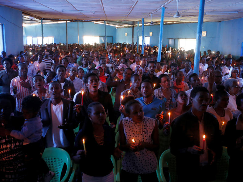 محتجون يحملون شموعاً ويؤدون الصلاة في الكنيسة اللوثرية على ارواح قتلى المظاهرات الأخيرة (ا ف ب)