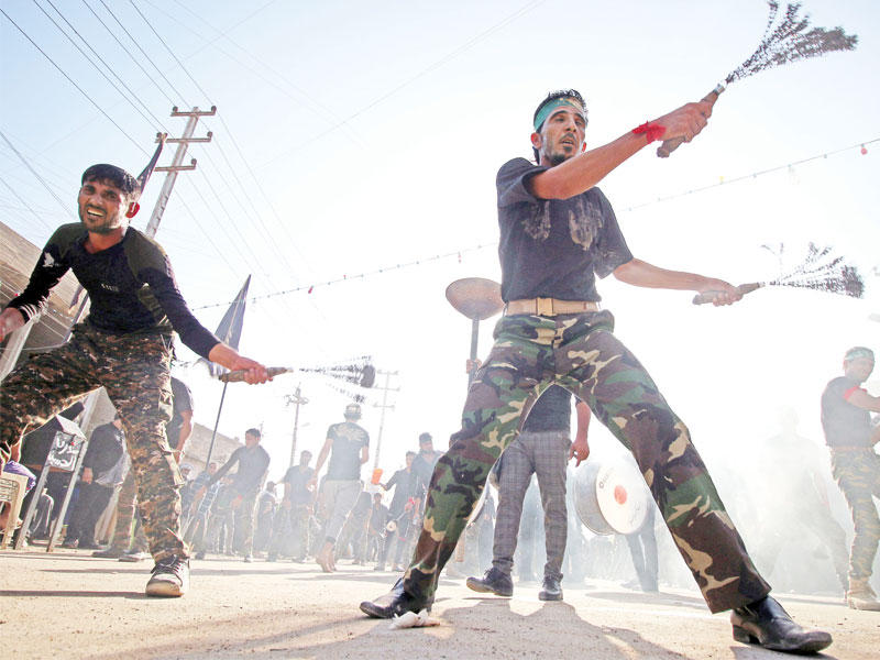 عراقيون يجلدون أنفسهم في إطار إحياء ذكرى عاشوراء بالبصرة أمسt(أ ف ب)