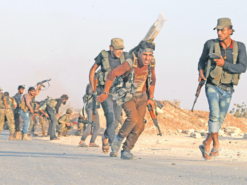 مقاتلون من الجيش الحر يعيدون تمركزهم على خط مواجهة «داعش» في منطقة مرج دابق أمس الأول  (أ ف ب)