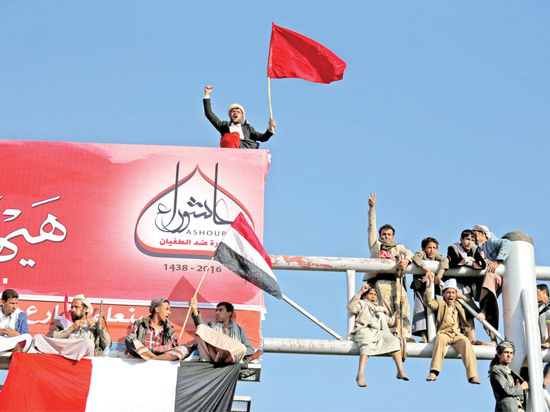 حوثيون يتسلقون لوحة إعلانية في صنعاء خلال إحياء ذكرى عاشوراء         (رويترز)