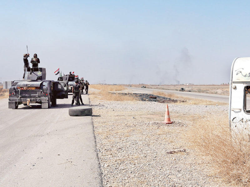 جنود عراقيون يتجاوزون نقطة أمنية لـ «داعش» قرب الحمدانية أمس (إي بي ايه)