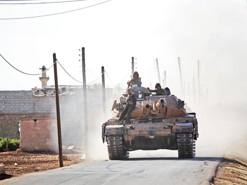 عناصر بالجيش الحر تدخل قرية الغوز في ريف حلب الشمالي أمس الأول على متن دبابة تركية   (رويترز)
