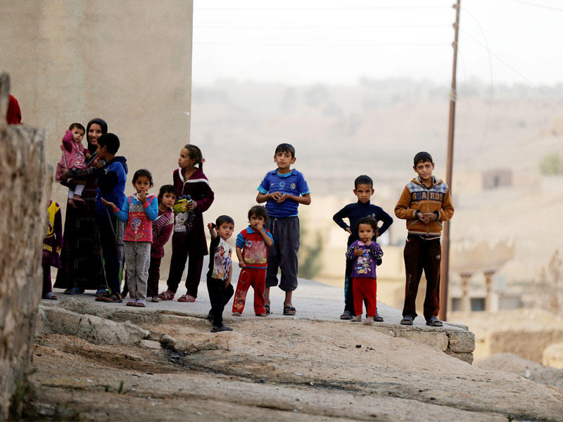 أطفال عراقيون في بلدة الخالدية بعد تحريرها من «داعش» أمس (رويترز)