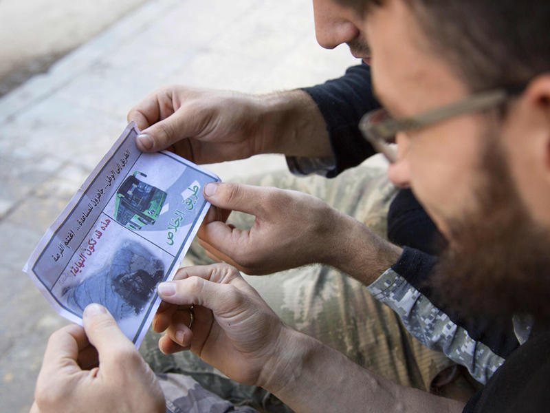 مقاتلون تابعون لفيلق الشام يقرأون احدى المنشورات التي القاها النظام السوري فوق حلب لتشجعهم على الانسحاب من المنطقة المحاصرة وسط الهدنة الحالية