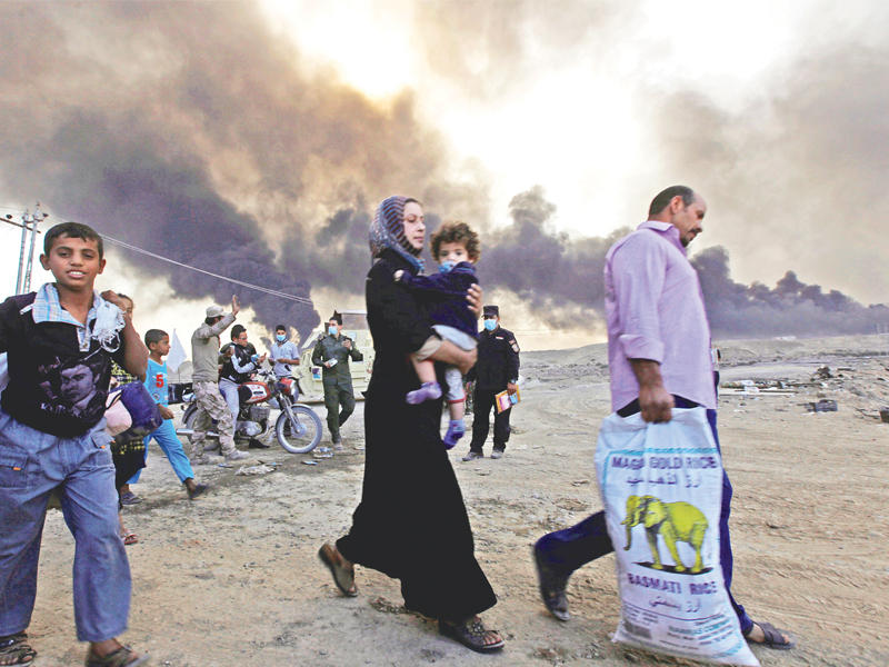 مدنيون يعودون إلى قراهم بعد طرد داعش منها في القيارة جنوب الموصل أمس	(رويترز)