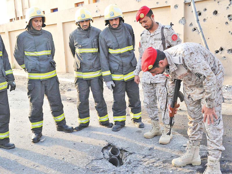 جنديان سعوديان يتفقدان مع عناصر الدفاع المدني بقايا صاروخ كاتيوشا سقط وسط بلدة الحنبكة بمحافظة العارضة أمس الأول                 (واس)