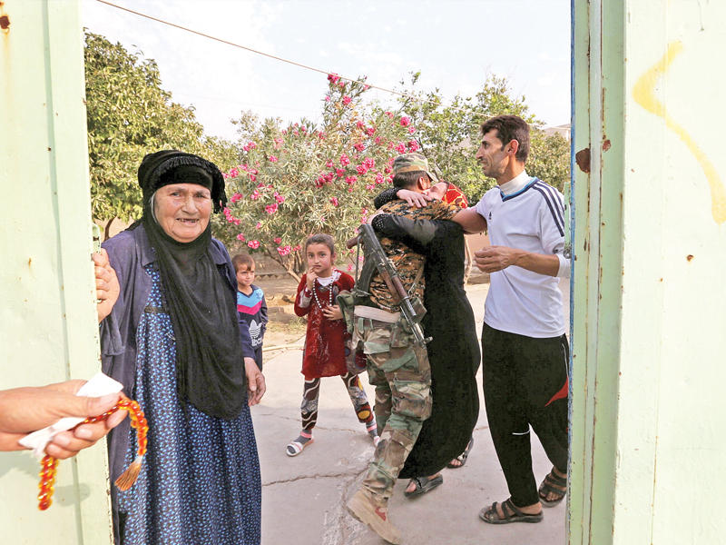 مقاتل في البيشمركة يحضن شقيقته في قرية الفاضلية بعد تحرير البلدة الواقعة قرب بعشيقة شمال الموصل من «داعش» أمس (رويترز)