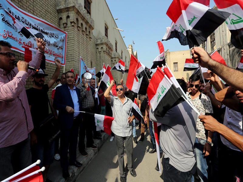 عراقيون يتظاهرون رفضاً لقرار منع المشروبات الكحولية في بغداد أمس  (إي بي إيه)