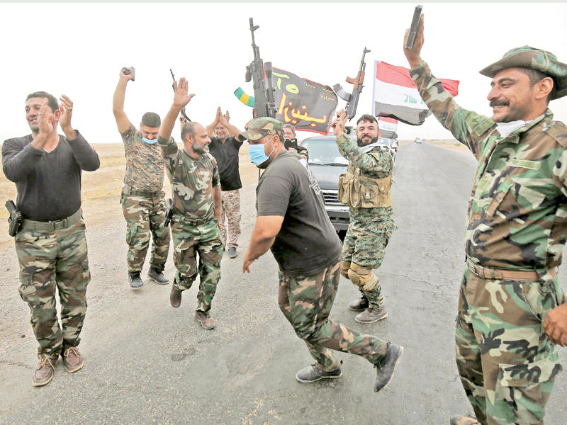 مقاتلون عراقيون من الجيش و«الحشد» يحتفلون على الجبهة جنوب الموصل أمس الأول (أ ف ب)