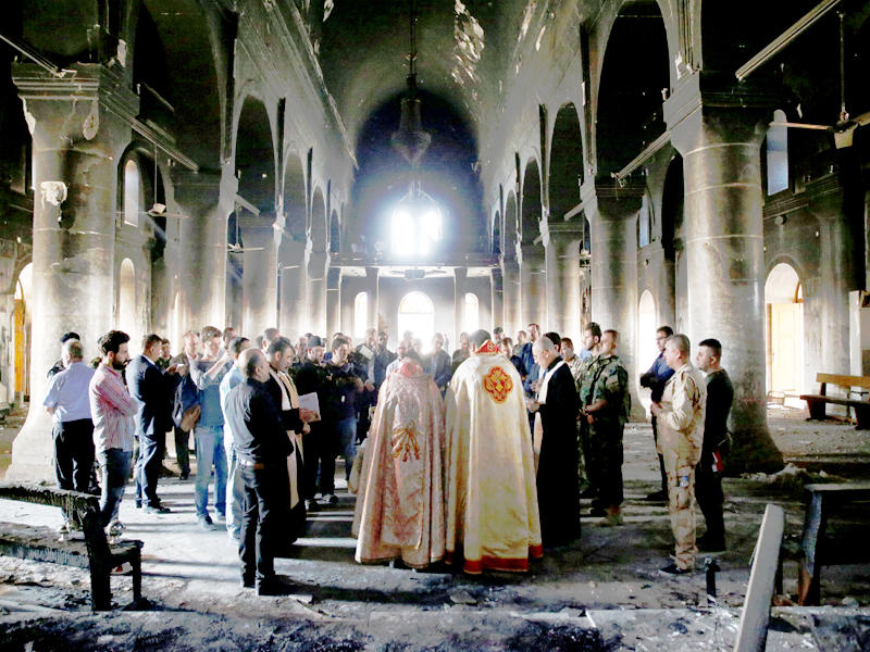 مسيحيون عراقيون يحيون أول قداس أحد أمس في كنيسة حرقها «داعش» في قرة قوشt(رويترز)