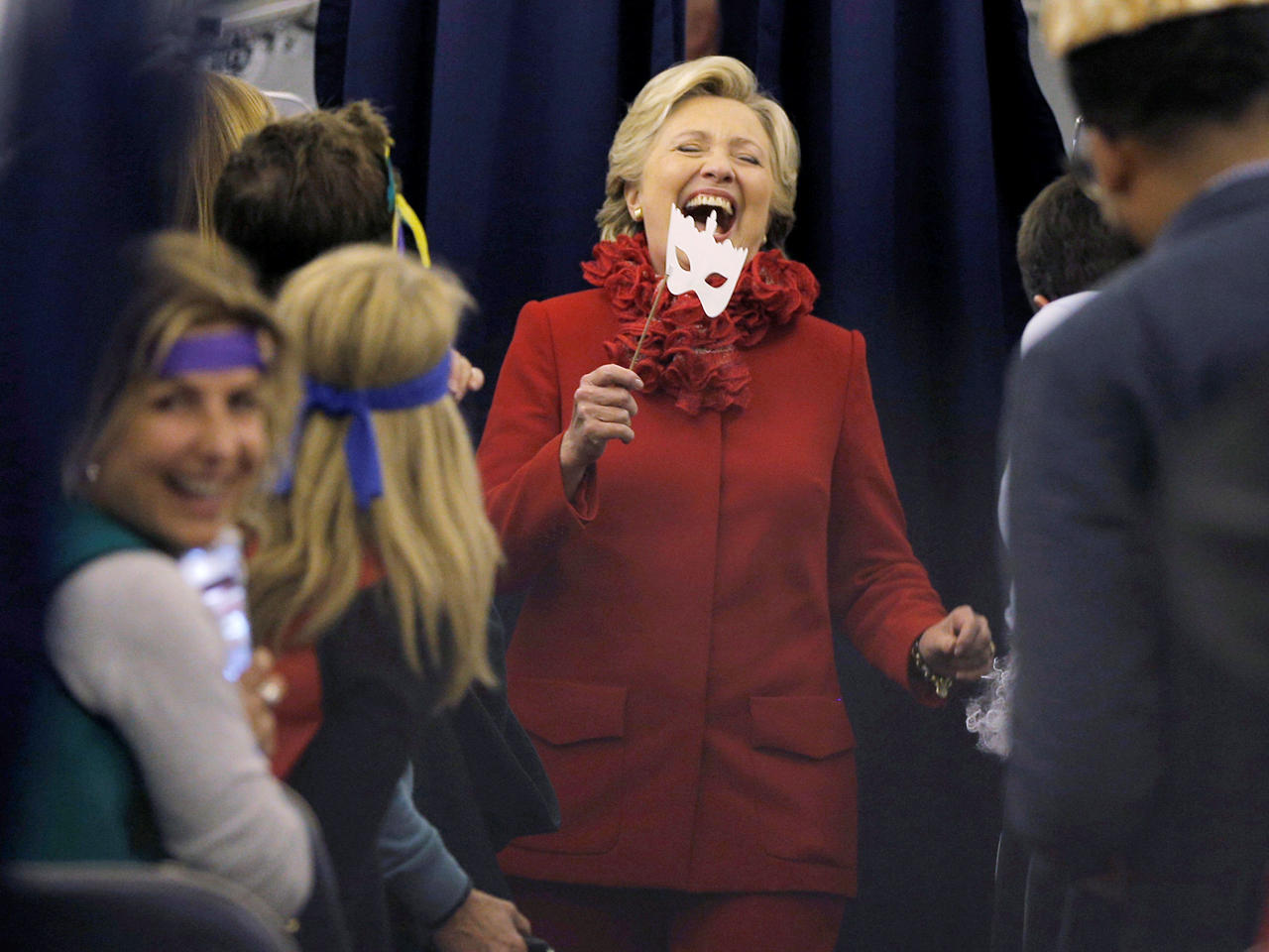 كلينتون في لحظة مرح بقناع هالوين مع أعضاء حملتها على متن طائرة