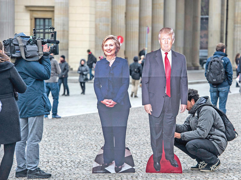 مجسمان من الكارتون لكلينتون وترامب وضعا في برلين أمس   (أي بي أيه)