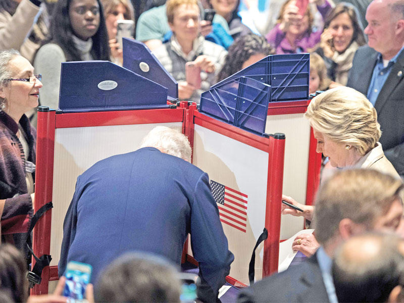 كلينتون وزوجها الرئيس السابق بيل يدليان بصوتيهما في نيويورك أمس (أ ف ب)