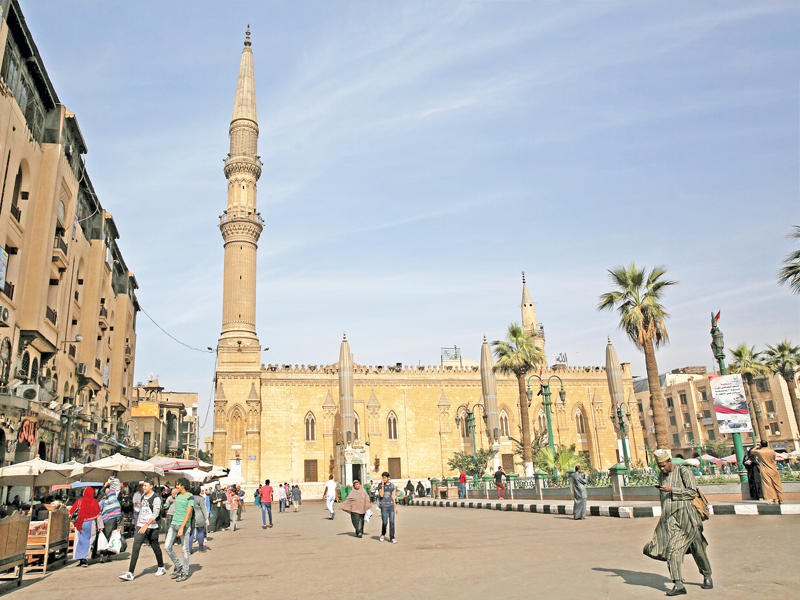 مصريون يتسوقون من أحد الأسواق بجوار مسجد الحسين وسط القاهرة القديمة أمس (رويترز)