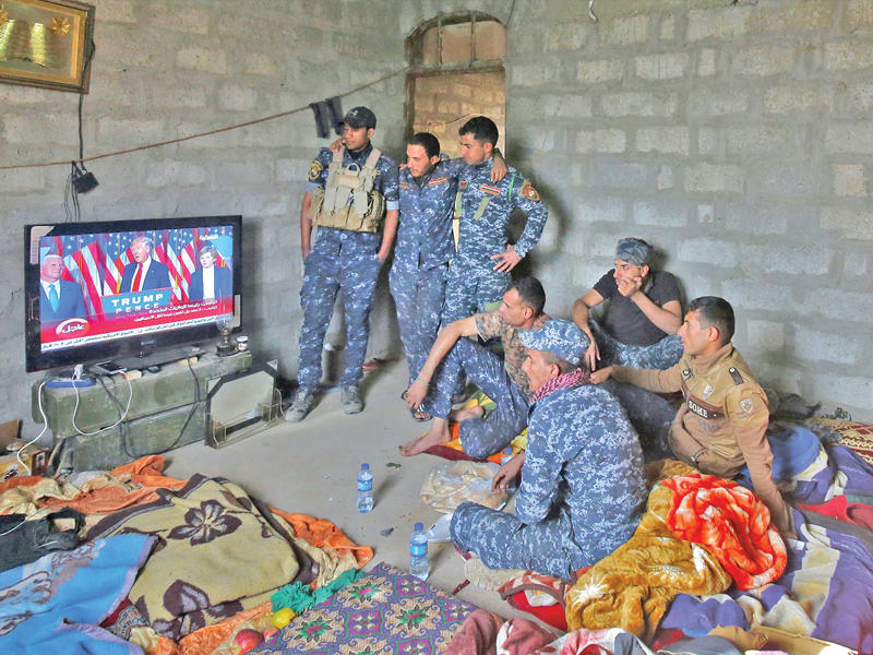 جنود عراقيون يتابعون نتائج الانتخابات الأميركية في قرية عربيد على مشارف الموصل فجر أمس  (أ ف ب) 