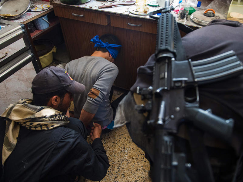 أحد افراق الفرقة الذهبية لمكافحة الارهاب يقيد عنصرين من تنظيم داعش عثر عليهما مختبئين في أحد المنازل ضمن الأحياء المحررة في الموصل