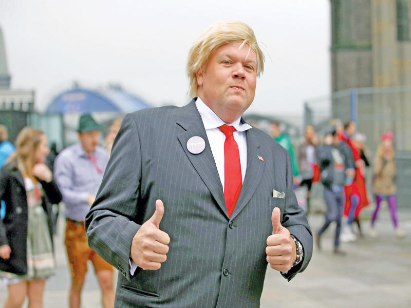 ألماني متنكر في هيئة ترامب خلال كرنفال كولونيا الكوميدي التقليدي الذي يشتهر بتقليد شخصيات عالمية وألمانية أمس (اي بي ايه)