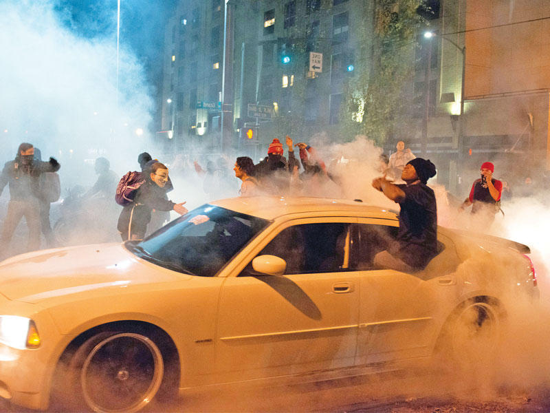 جانب من التظاهرات ضد ترامب في بورتلاند مساء أمس الأول والتي صنفتها الشرطة أعمال شغب (رويترز)