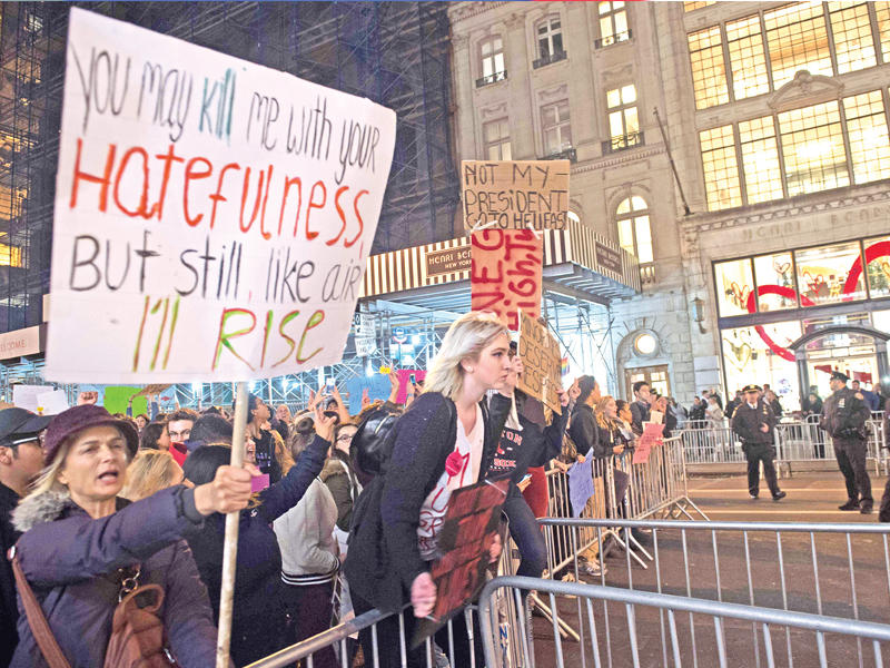 أميركية تحاول اجتياز حواجز الشرطة خلال احتجاجات ضد ترامب في مانهاتن بنيويورك أمس الأول (أ ف ب)