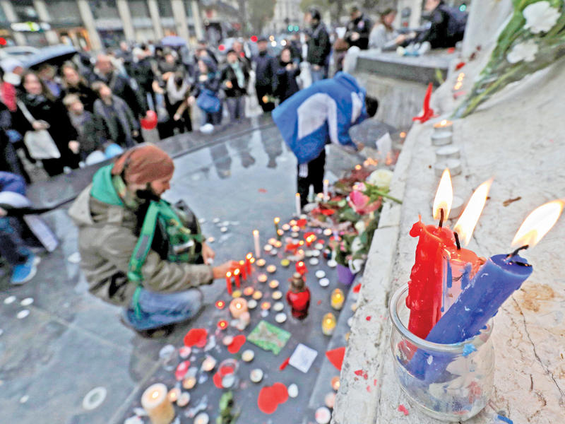 شموع بألوان العلم الفرنسي خلال إحياء ذكرى هجمات 13 نوفمبر في ساحة الجمهورية بباريس أمس (رويترز)