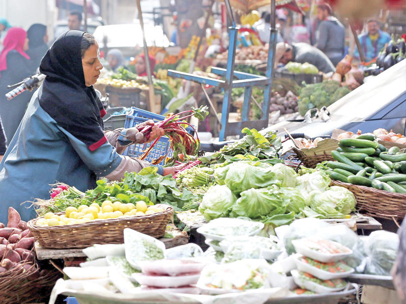 مصريون يتسوقون من سوق للخضار في منطقة الدقي في القاهرة أمس الأول   (إي بي أيه)