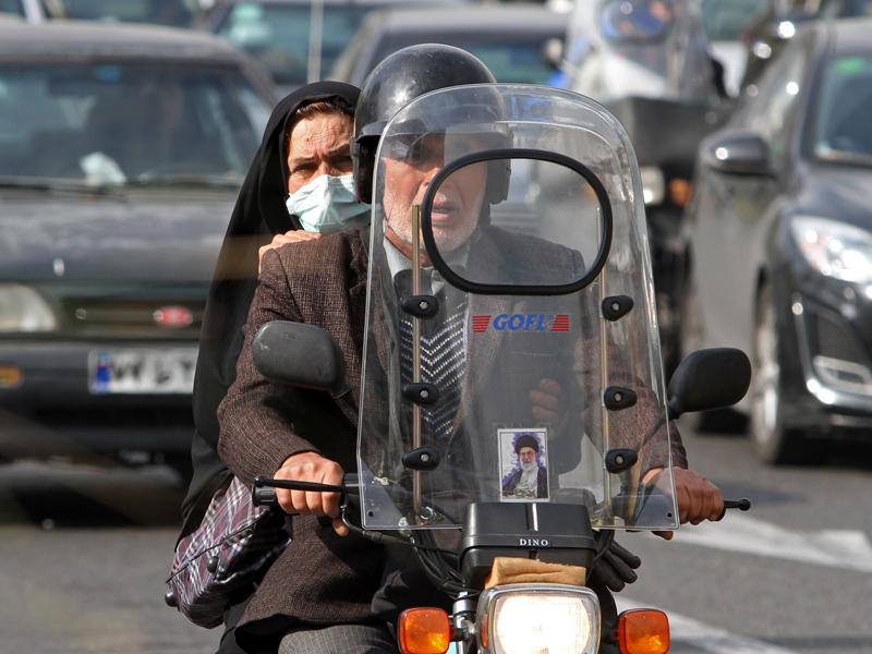 سيدة ايرانية تردي كماما خلال ركوبها للدرجاة النارية مع احد اقربائها في شوارع العاصمة طهران (ا ف ب)